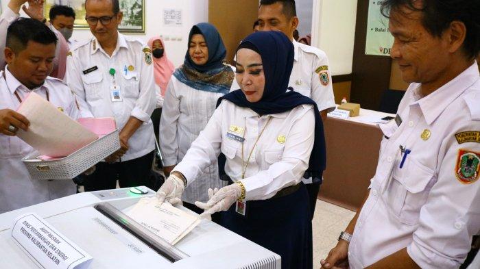 Kepala Dispersip Kalsel, Nurliani Dardie (dua kiri) memamerkan penghancuran berkas arsip.