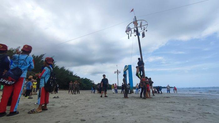 Keseruan anak-anak mengikuti panjat pinang pantai di Festival Kreativitas Anak Kampung Nelayan di Pantai Gedambaan.