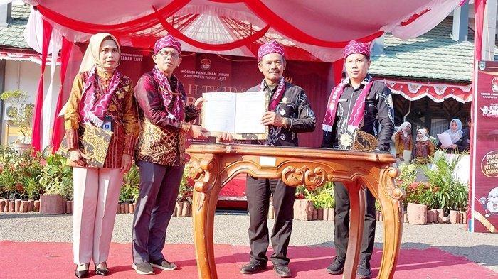 Ketua KPU Kabupaten Tanah Laut (Tala), Rudy Pratikno (kiri), dan Ketua KPU Kabupaten Tanah Bumbu, Puryadi, memperlihatkan berita acara serah terima Kirab Pemilu 2024, Jumat (1/9/2023).