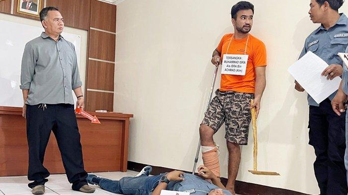 Pelaku pembunuhan, Muhammad Isra alias Isra, saat di Kantor Polsekta Banjarmasin Utara, memeragakan menindihkan kakinya di atas tubuh korban, Rabu (16/8/2023) pagi.