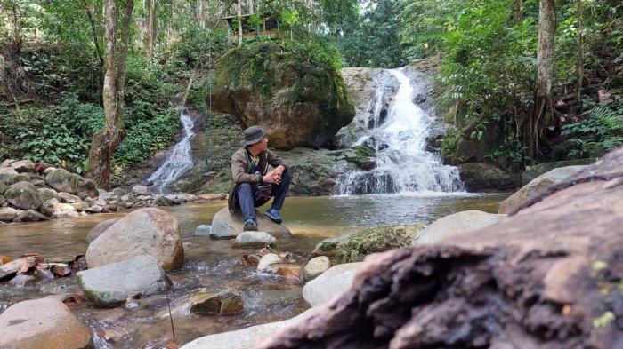 Pelancong wisata berfoto di objek wisata alam Riam Bainggi Balangan.