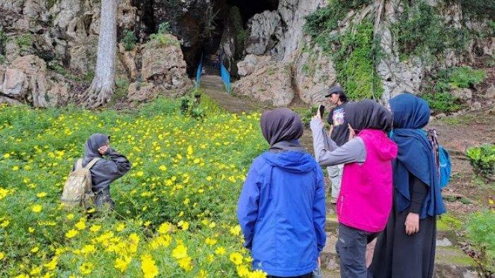 MENIKMATI KEINDAHAN GUA -Pengunjung GUa Batu Hapu berfoto di bunga yang menghiasi di mulut goa alam yang berada di Desa Batu Hapu, Kecamatan Hatungun, Kabupaten Tapin, Minggu (2/2/2025)