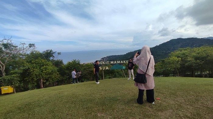 Pengunjung berfoto di kawasan Wisata Bukit Mamake, Desa Sarang Tiung, Kecamatan Pulau Laut Sigam, Kabupaten Kotabaru.