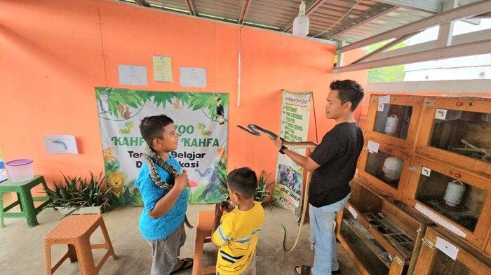 Pengunjung Mini Zoo di Desa Halong, Balangan diajak berinteraksi dengan ular, Kamis (29/8/2024).