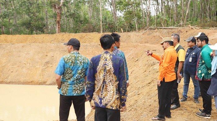 Penjabat Bupati, H Syamsir Rahman (baju oranye), saat meninjau lokasi pembuatan embung di Desa Alur, Kecamatan Jorong, Kabupaten Tanah Laut, Kamis (12/10/2023).
