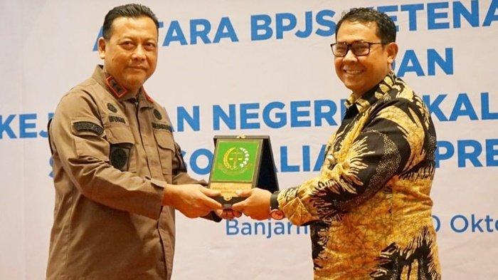 Penyerahan cendera mata setelah penandatangan kerja sama Kejaksaan Negeri Banjarbaru dan Badan Penyelenggara Jaminan Sosial Ketenagakerjaan (BPJamsostek).