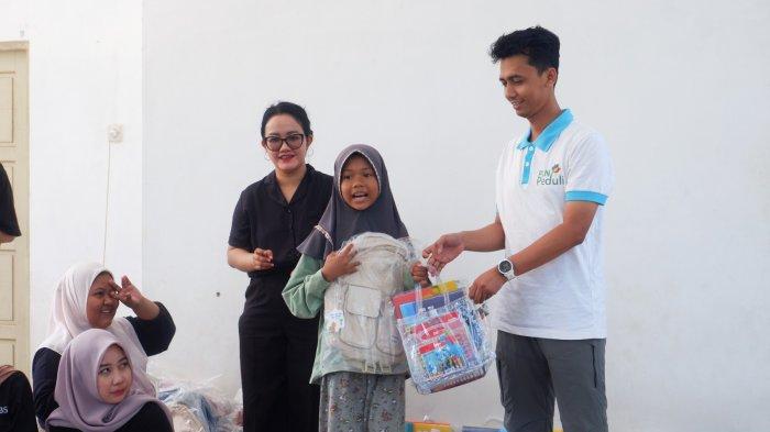 Penyerahan paket belajar kepada salah satu anak penerima manfaat di desa Tiwingan Lama