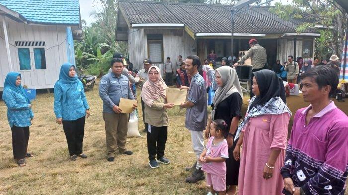 Pj Bupati Tabalong, Hj Hamida Munawarah menyerahkan hasil layanan pembuatan dokumen kependudukan untuk warga Desa Salikung dan Sungai Kumap.