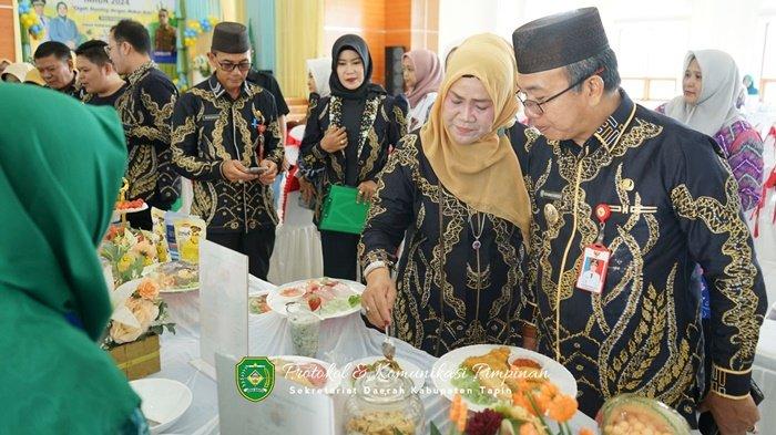 Pj Bupati Tapin, Muhammad Syarifuddin bersama Pj Ketua TP PKK Tapin, Masrupah meninjau kreasi peserta Lomba Memasak Serba Ikan.