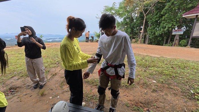 TYROLEAN TRAVERSE - Reporter Banjarmasin Post, Syaiful Riki dibantu pemandu memakai perlengkapan standar sebelum menjajal kegiatan tyrolean traverse di Bukit Matang Kaladan, Kecamatan Aranio, Kabupaten Banjar, Kalsel.