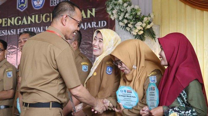 Sekda HSS menyerahkan penghargaan kepada pemenang Festival Lokal belajar.id Tingkat Kabupaten HSS Tahun 2023.