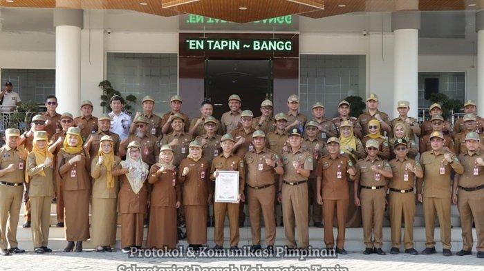 Sekretaris Daerah Kabupaten Tapin H Sufiansyah berfoto bersama dengan ASN sambil memegangi  plakat penghargaan SAKIP 2024 di pintu utama Kantor Bupati Tapin, Kawasan Rantau Baru, Senin (7/10/2024)