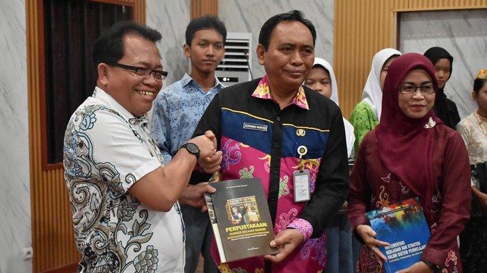 TERIMA : Pj Bupati Kapuas Erlin Hardi dan Bunda Literasi Kabupaten Kapuas Ny. Agustina Erlin Hardi menerima Buku Karangan Kepala Dinas Sarpustaka Kapuas Dr H Suwarno Muriyat usai membuka Lomba Pemilihan Duta Baca Tingkat SLTA/Sederajat Kabupaten Kapuas Tahun 2024, bertempat di Huma Betang Bukit Ngelangkang, Kamis (13/6).