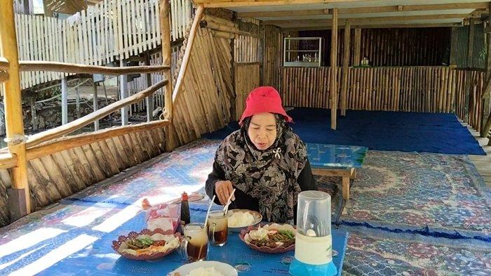 WISATA-Replika perahu bambu di atas kolam ikan, menjadi tempat akan pengujung yang pesan makanan di objek wisata Kampung Bambu. 