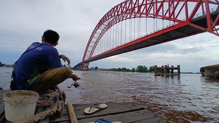 Warga memancing di area bawah Jembatan Rumpiang, Batola.