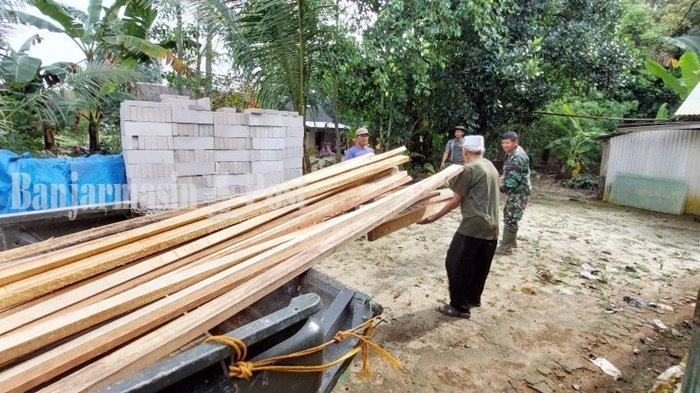 Sandi Wirya (berpeci) senang dan turut membantu anggota Kodim 1009/TLa menurunkan material untuk bedah rumahnya di Desa Telagalangsat, Kecamatan Takisung, Kabupaten Tanah Laut (Tala), Provinsi Kalimantan Selatan. beberapa hari lalu.