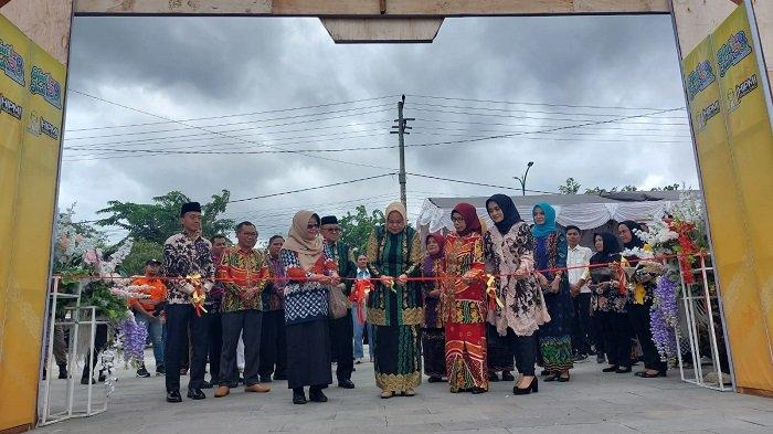 Ketua TP PKK Kabupaten Tabalong, Syarifah Syifa memotong pita pada gerbang Pekan Raya Tabalong 2023 sebagai simbolis pembukaan acara Pekan Raya Tabalong 2023, Kamis (7/12/2023).
 