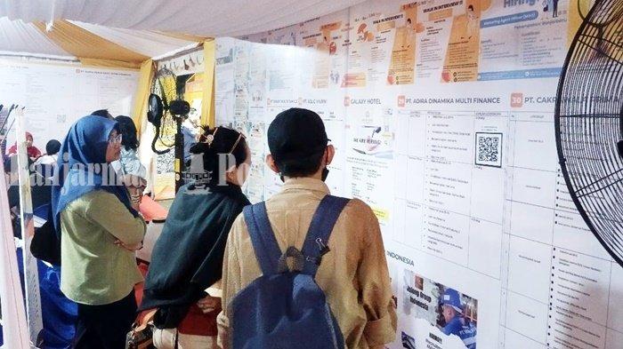 Warga melihat daftar lowongan kerja (loker) pada stan job fair di ajang Kalsel Expo Kalsel, Lapangan Murdjani, Kota Banjarbaru, Provinsi Kalimantan Selatan, Minggu (3/9/2023).