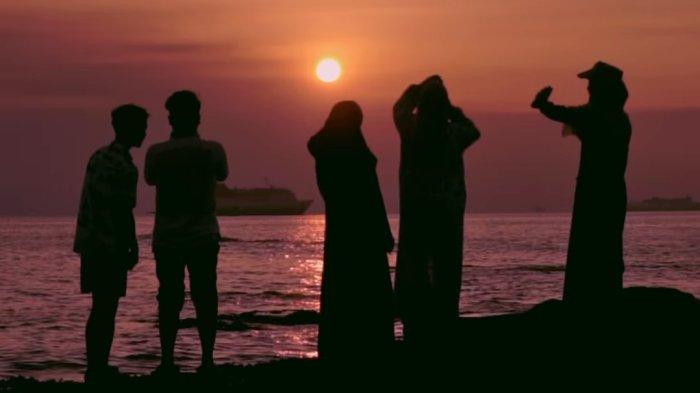 Wisatawan berfoto di Pulau Merak Kecil saat sunset.