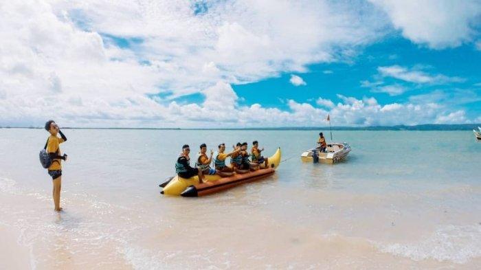 Wisatawan bermain banana boat di sekitar pantai pasir putih di Pulau Liwungan, yang berada di dekat Tanjung Lesung, di Kabupaten Pandeglang.