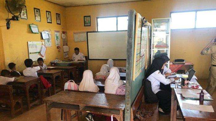 BERBAGI RUANGAN - Suasana belajar siswa kelas 3 SDN 3 Kaliombo, Kecamatan Pecangaan, Kabupaten Jepara, Jawa Tengah, yang harus berbagi ruang dengan guru, Senin (16/6/2025). Minimnya ruangan di sekolah tersebut membuat pihak sekolah menyekat ruang yang ada untuk kelas dan kantor. 