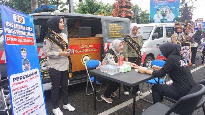 STAN POLRES PURBALINGGA — Petugas Polres Purbalingga memberikan layanan perpanjangan SIM, STNK, dan pembayaran pajak kendaraan di stan yang dibuka dalam car free day di Alun-alun Purbalingga, Minggu (22/6/2025).