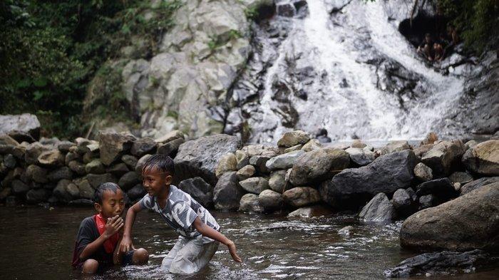 Dua bocah sedang bermain air di kolam wisata Air Terjun Wadung Kecemplung, Kecamatan Batealit, Kabupaten Jepara, Jateng, Minggu (16/6/2024).