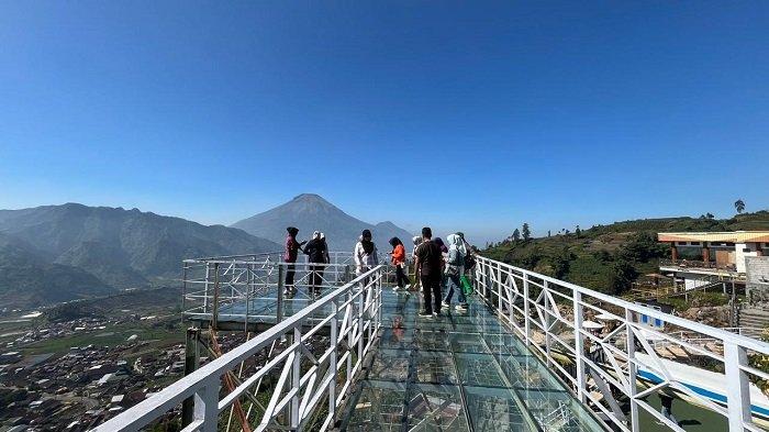 Wisatawan menikmati wahana jembatan kaca di tempat wisata Pintu Langit Wonosobo, Jumat (9/8/2024).