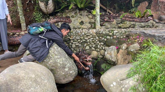 Pengunjung hendak mengambil air yang diyakini suci di Sendang Sampang. Air suci ini juga dipercaya dapat membuang aura buruk pada seseorang, Selasa (28/5/2024).