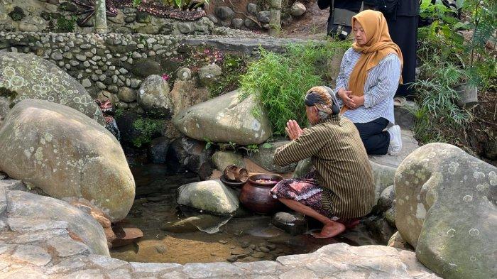 Pengunjung hendak mengambil air yang diyakini suci di Sendang Sampang. Air suci ini juga dipercaya dapat membuang aura buruk pada seseorang, Selasa (28/5/2024).