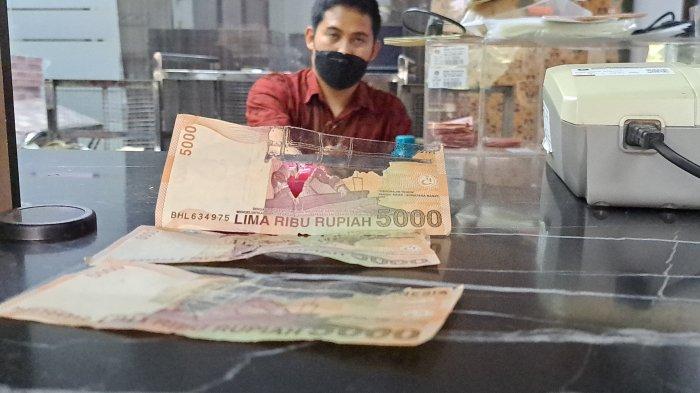 Petugas BI kantor wilayah Purwokerto saat menunjukan contoh uang rusak yang tidak layak, Kamis (7/9/2023).