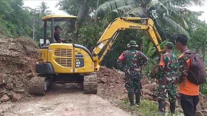 Tim gabungan saat melakukan kerja bakti membersihkan material longsor yang menutup ruas jalan di Desa Bantarpanjang, Kecamatan Cimanggu, Kabupaten Cilacap, Senin (9/12/204). Tebing bebatuan setinggi 20 meter mengalami longsor usai diguyur hujan deras dengan intensitas tinggi di wilayah tersebut.