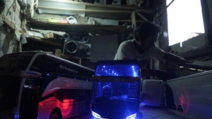 Ahmad Yusron, seorang pengrajin miniatur alat transportasi asal Desa Wonobodro, Kecamatan Blado Kabupaten Batang menunjukkan karyanya membuat miniatur bus.