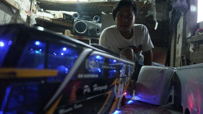 Ahmad Yusron, seorang pengrajin miniatur alat transportasi asal Desa Wonobodro, Kecamatan Blado Kabupaten Batang menunjukkan karyanya membuat miniatur bus.