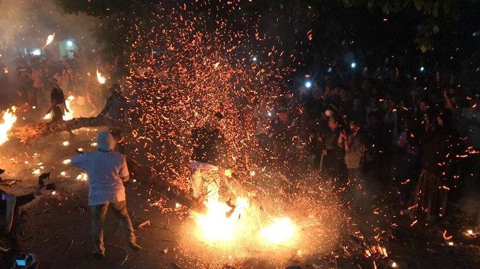 Peserta saling serang dalam perang obor di Desa Tegalsambi, Kecamatan Tahunan, Kabupaten Jepara, Senin (20/5/2024). Tradisi tahunan ini digelar warga sebagai bagian dari tolak bala sekaligus ucapan syukur kepada Tuhan Yang Maha Esa.