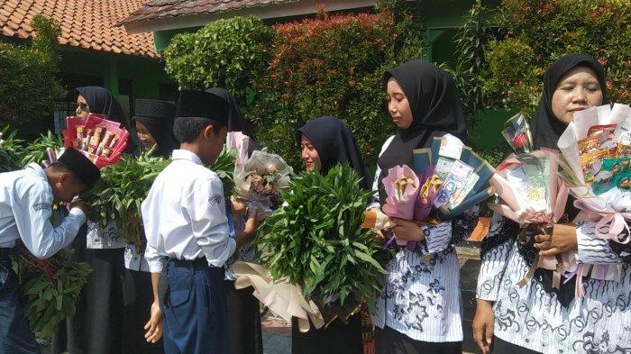 Siswa SMP Sultan Agung Kawunganten, Cilacap saat memberikan hadiah berupa sayur mayur untuk gurunya di momen peringatan Hari Guru Nasional, Senin (25/11/2024).