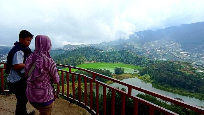 Wisatawan menikmati hamparan pemandangan alam dari tempat wisata Batu Pandang Ratapan Angin Wonosobo di Desa Jujugan, Kecamatan Kejejar, Wonosobo, Minggu (14/5/2023). Dari tempat ini, wisatawan dapat melihat kawasan wisata Dieng dari ketinggian.
