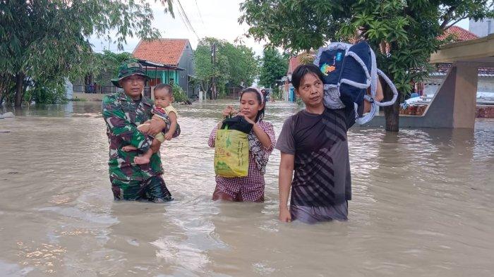 Anggota TNI membantu membawakan barang warga saat evakuasi dari bencana. Banjir cukup besar melanda Kabupaten Brebes. Tercatat ada tujuh kecamatan terendam luapan Sungai Pemali.
