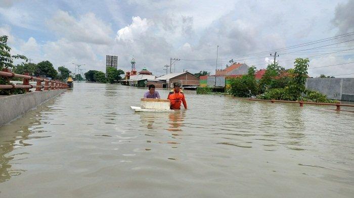 Warga Demak menerobos banjir yang menggenangi Jembatan Tanggulangin, Minggu (17/3/2024). Banjir kembali menggenangi Jalan Pantura Demak dan permukiman warga di Kecamatan Karanganyar akibat tanggul Sungai Wulan jebol.
