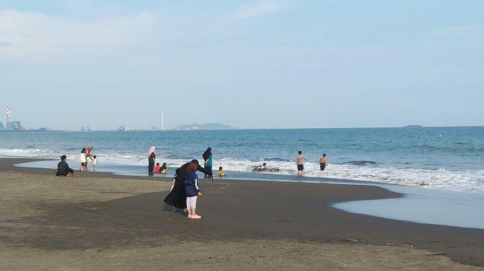Wisatawan menikmati Pantai Kamulyan Cilacap saat momen libur Nataru 2023, Selasa (26/12/2023). Wisatawan dari berbagai daerah menyerbu objek wisata gratis ini, terutama pada sore hari.