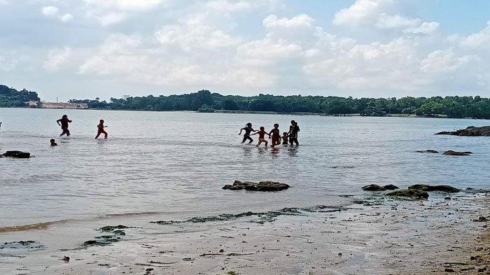 Anak-anak bermain air di Pantai Dangas, Sekupang, Batam, Senin (4/7/2022).
