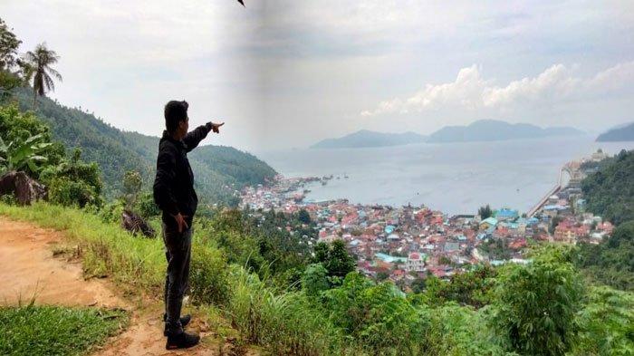 Seorang pengunjung saat melihat potret pemandangan alam Pulau Siantan dari atas Bukit Tengkorak (Buteng) Kelurahan Tarempa, Kabupaten Anambas, Senin (5/9/2022). Tempat ini kerap didatangi wisatawan yang berkunjung ke Anambas.