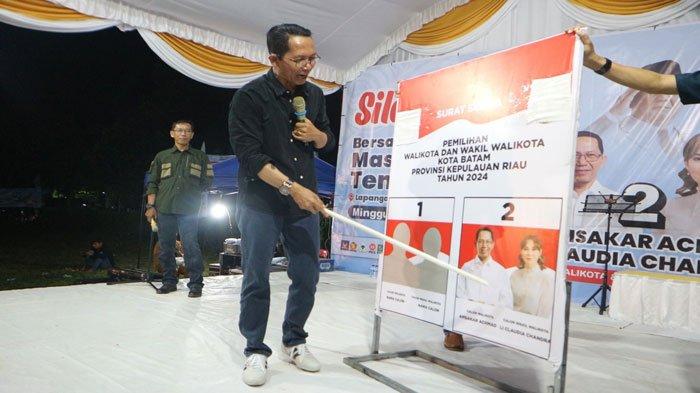 SILATURAHMI - Calon Wali Kota Batam periode 2024-2029 Amsakar Achmad saat memperagakan coblos nomor urut 2 untuk Pilkada Batam saat menghadiri silaturahmi bersama warga Tembesi, di Lapangan Bola Helang Perkasa, Minggu (6/10/2024) malam