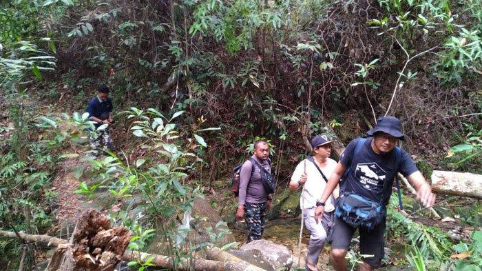 Pendaki melewati setapak jalan bebatuan menuju puncak wisata alam Gunung Jantan Karimun, Kamis (7/7/2022).
