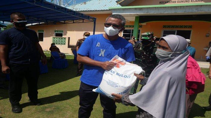 SERAHKAN BERAS-Apri Sujadi sewaktu menjadi Bupati Bintan menyerahkan bantuan beras PPKM seberat 10 kilogram kepada warga Desa Malang Rapat Bintan, Kamis (29/7/2021)