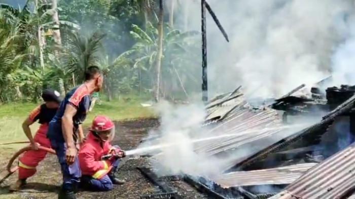 KEBAKARAN DI NATUNA - Tim Damkar berjibaku memadamkan api yang menghanguskan satu unit rumah panggung kayu, di Jalan Air Kumbik, Kelurahan Ranai Darat, Kecamatan Bunguran Timur, Kabupaten Natuna, Provinsi Kepulauan Riau (Kepri), Minggu (20/7/2025).