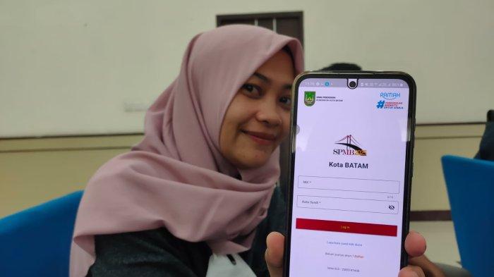 Seorang wanita menunjukkan aplikasi SPMB Kota Batam untuk pendaftaran sekolah, Kamis (22/5/2025)