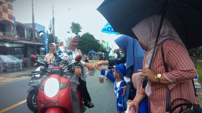 TAKJIL GRATIS - Murid TK Angkasa Lanud Raden Sadjad yang didampingi orang tua, saat membagikan takjil gratis kepada para pengendara di pertigaan Pantai Piwang, Kabupaten Natuna.
