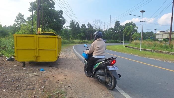 BAK SAMPAH DI BINTAN  - Seorang warga Bintan hendak membuang sampah di bak amrol KM 20, Gesek, Toapaya, Kabupaten Bintan, Provinsi Kepri, Rabu (23/7/2025).  Bak sampah di Bintan ini baru saja diganti oleh Pemerintah Kabupaten Bintan.