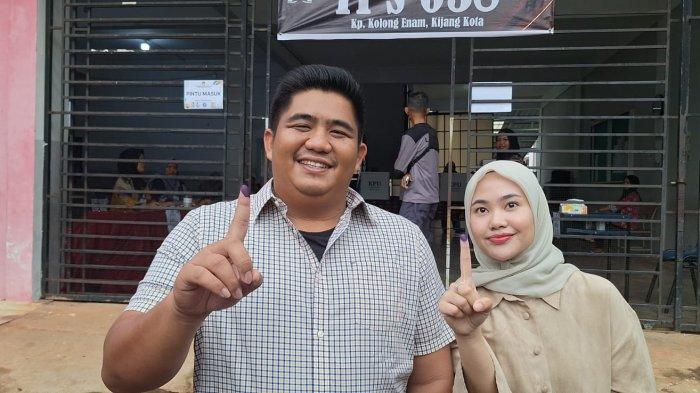 COBLOS  - Calon Bupati Bintan, Roby Kurniawan dan istrinya Hafizha Rahmadhani saat menggunakan hak suaranya di TPS 038 di Kampung Kolong Enam, Kelurahan Kijang Kota, Kecamatan Bintan Timur pada Rabu (27/11/2024).